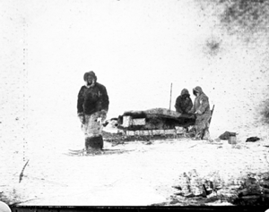 Image of Two men by upstanders; 1 on snowshoes